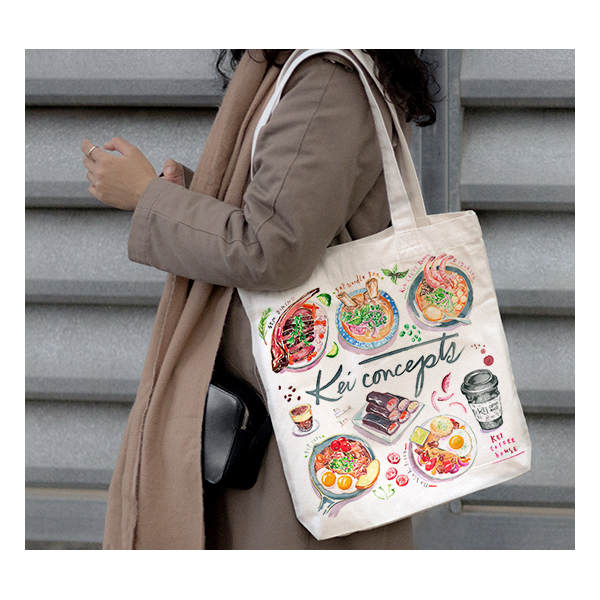 a lady with a tote bag with Asian food illustrations printed on it from Kei Concepts restaurants